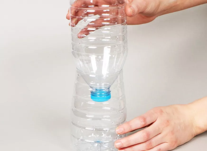Cómo invertir una botella de agua cortada para construir una clepsidra artesanal.