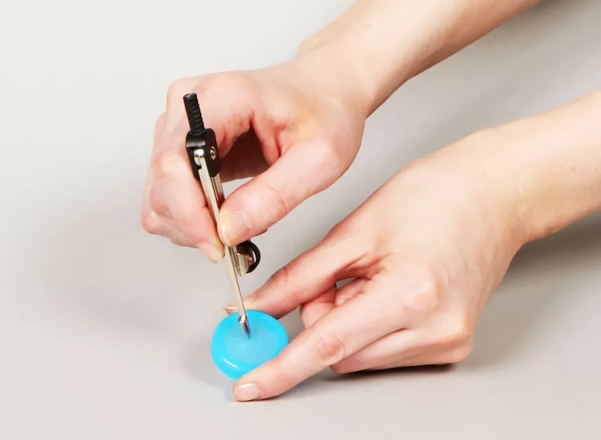 Cómo perforar el tapón de una botella de agua para construir una clepsidra artesanal.