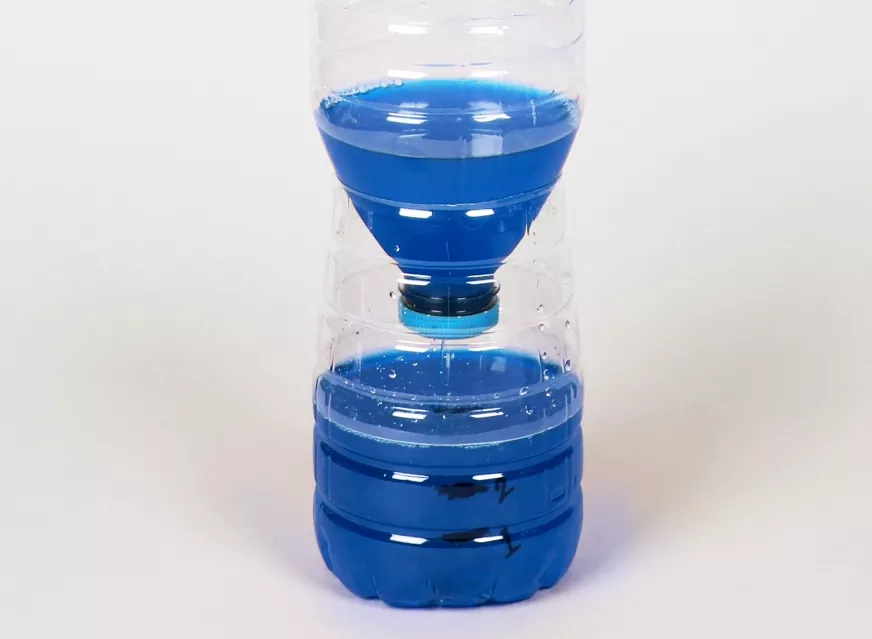 Una clepsidra artesanal terminada reutilizando una botella de agua de plástico.